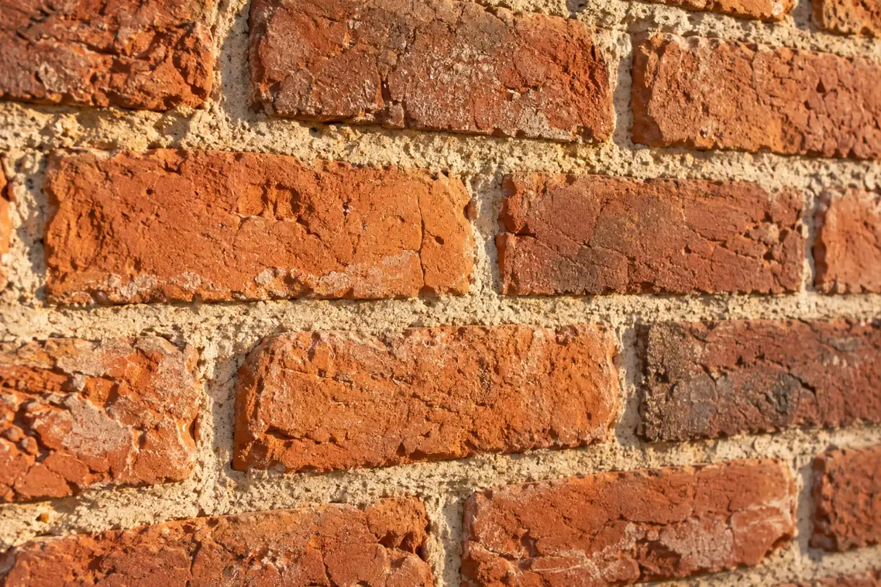 Close up of older soft brick with pale lime mortar joints